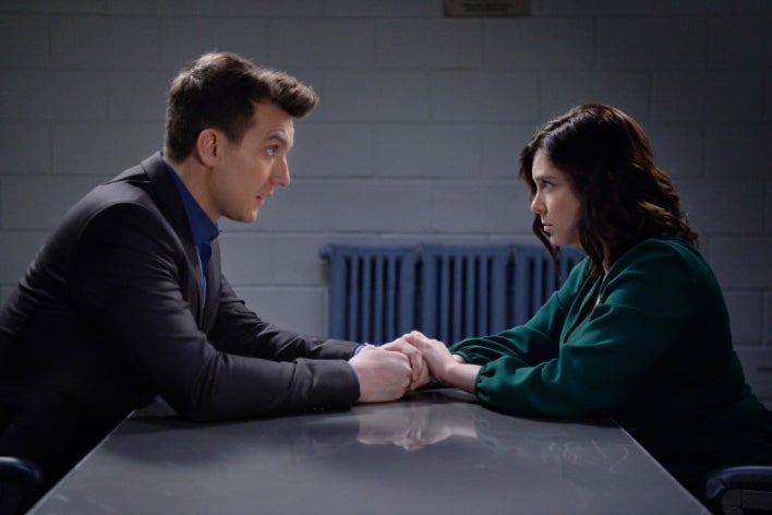 Scott Michael Foster as Nathaniel and Rachel Bloom as Rebecca hold hands in an interrogation room